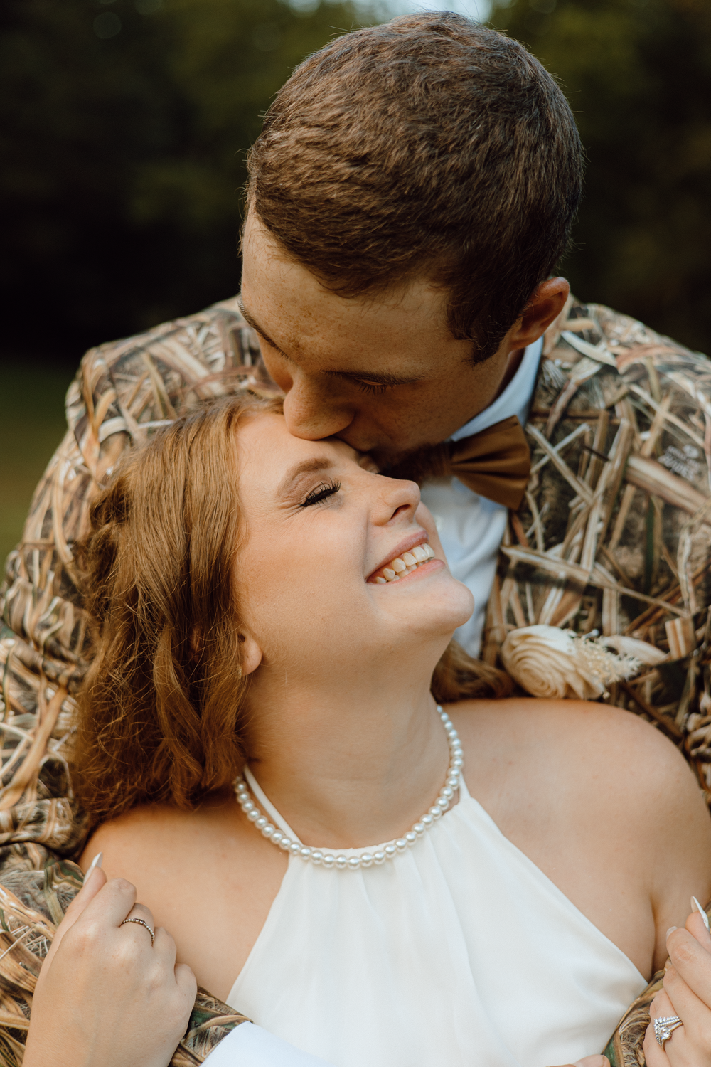 Intimate outdoor portrait series showing tender moments between newlyweds in camouflage and white.