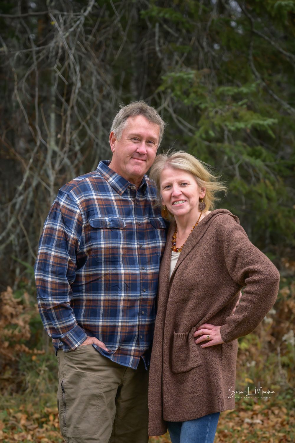couple posing against tree background
