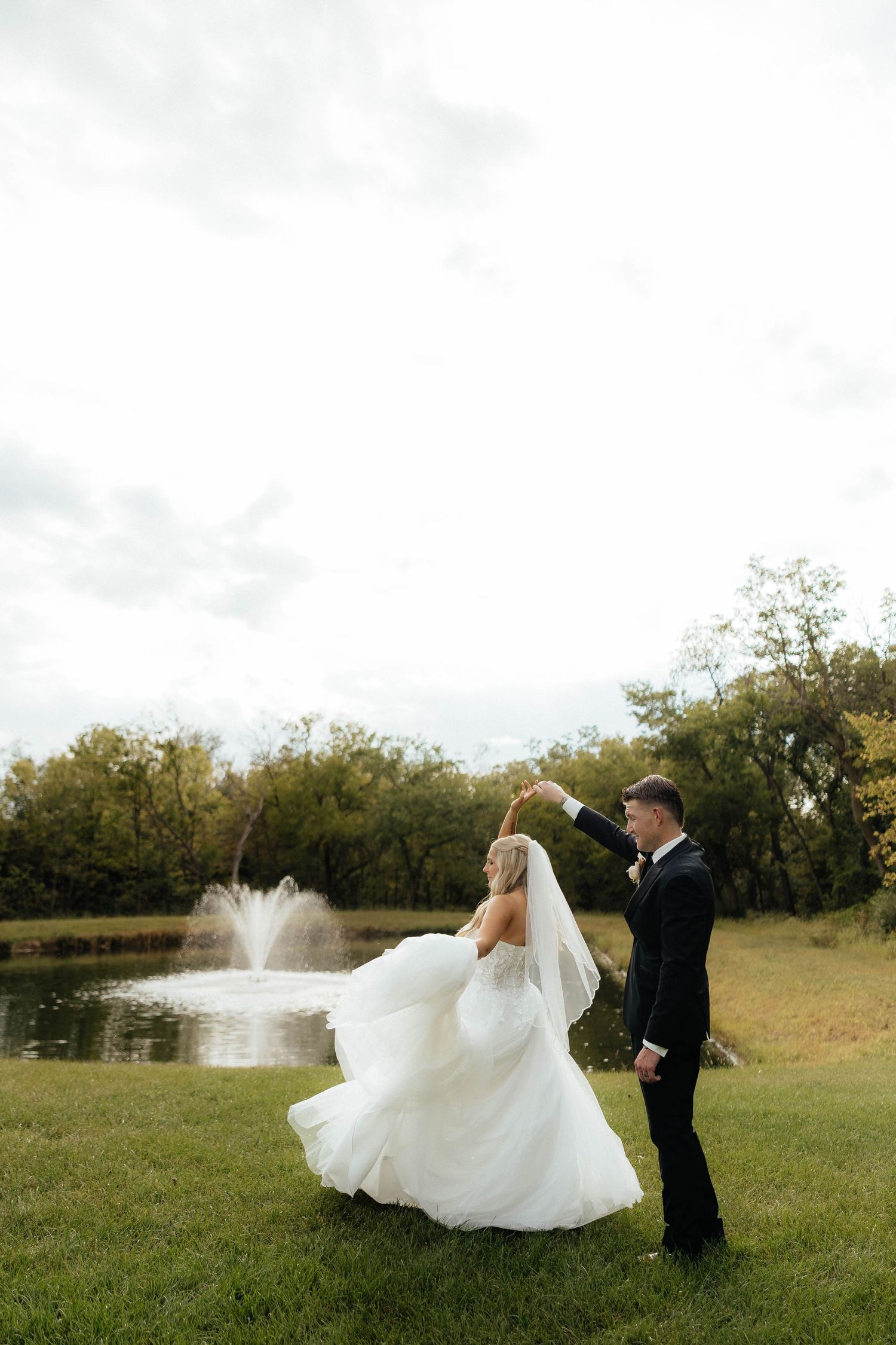 A romantic wedding moment of bride and groom captured in a sunlit forest with natural greenery backdrop.