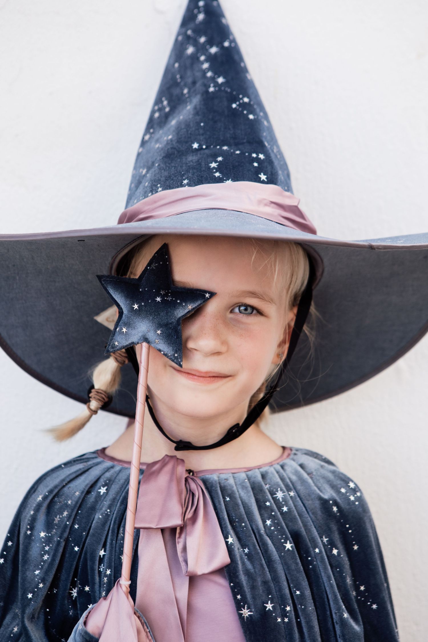 Magical Halloween costume featuring a starry witch hat and star wand against white background.