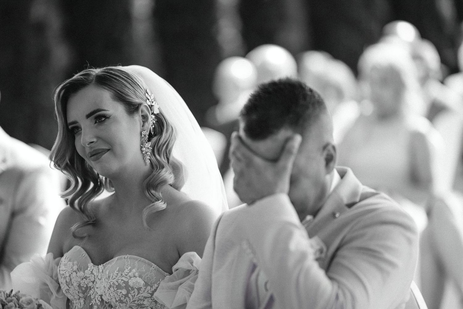 Black and white wedding photograph capturing emotional ceremony moment.