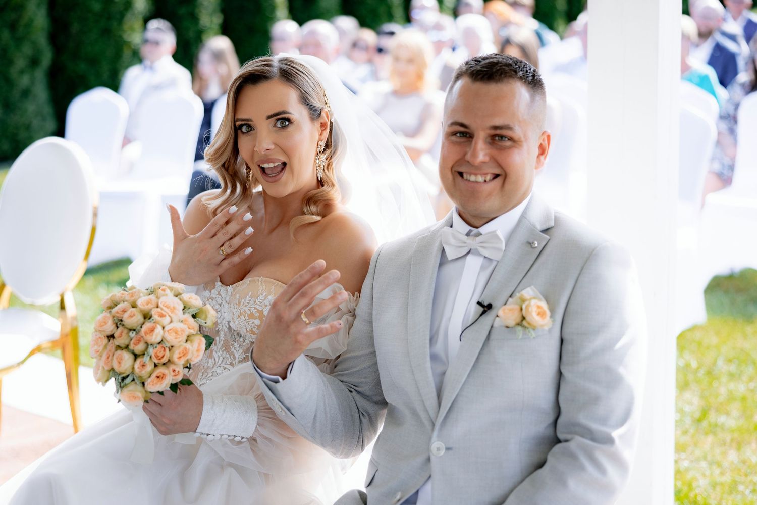 A joyful wedding ceremony moment captured outdoors with the couple showing excitement.
