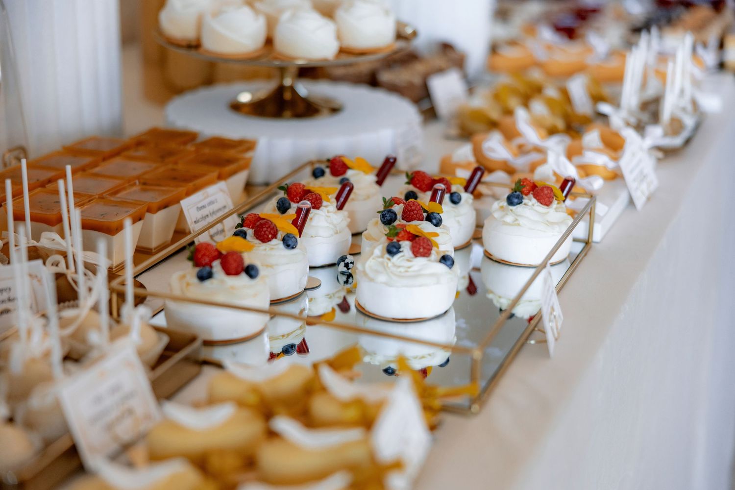 Assorted wedding desserts and mini pastries displayed on elegant tiered serving platters.