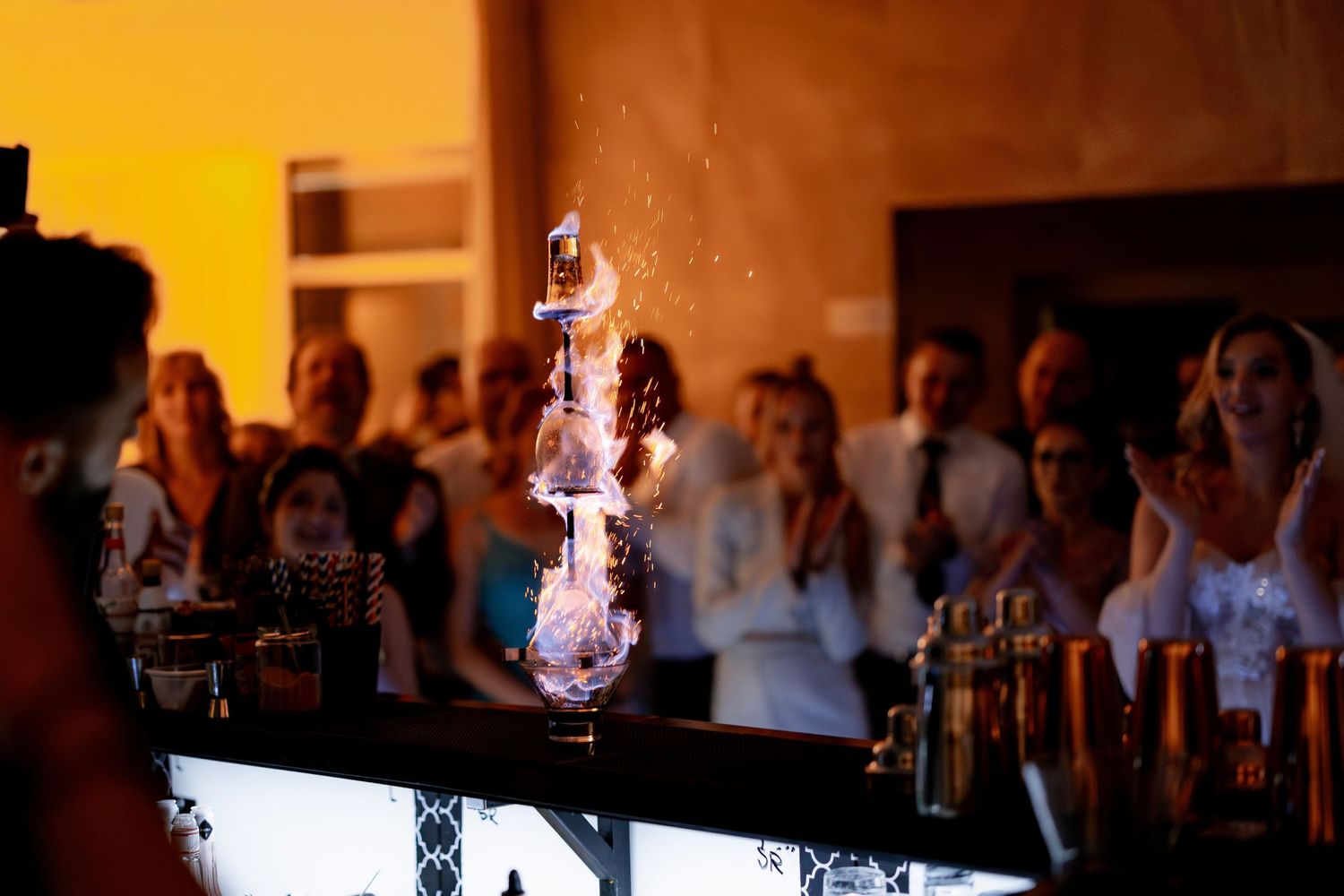Flaming cocktail display at wedding bar with illuminated smoke effect.