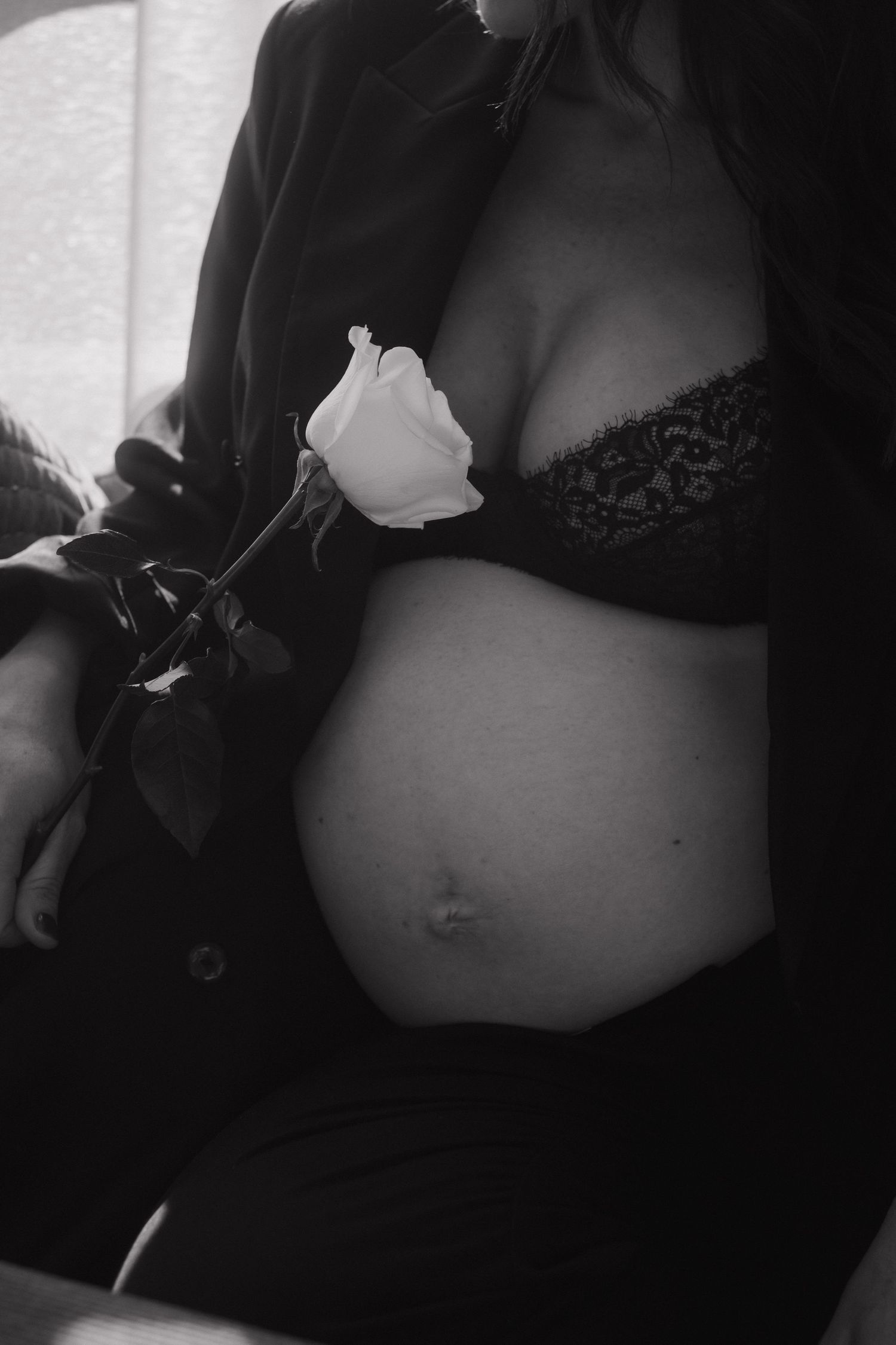 Artistic black and white maternity photo with white rose.