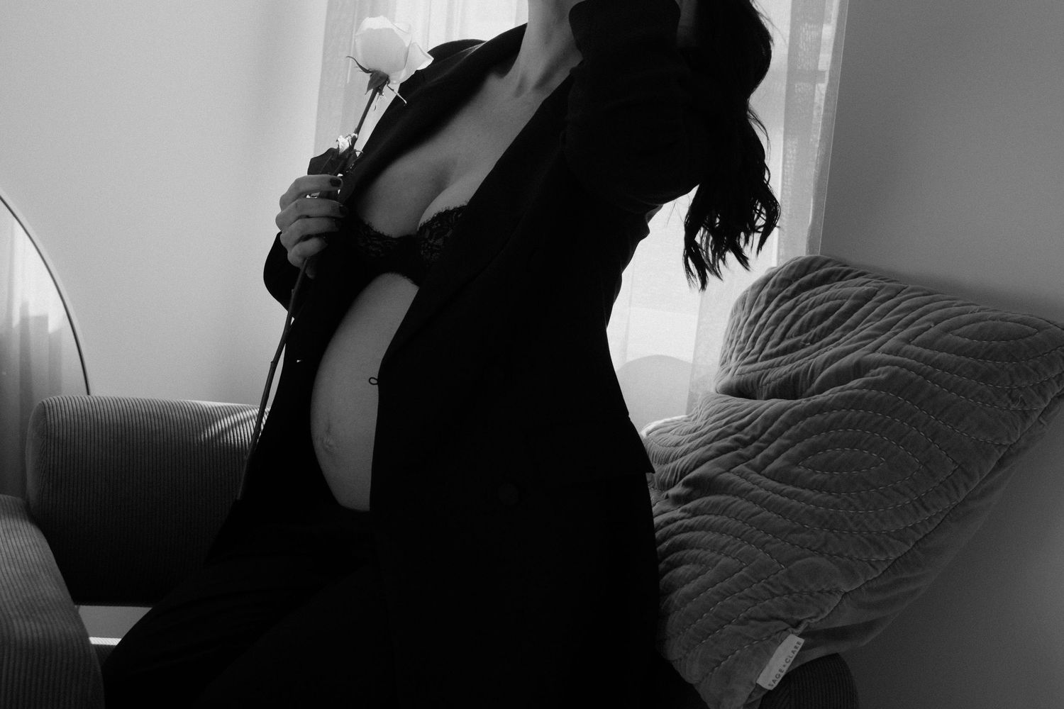 Dramatic black and white maternity silhouette holding flower.