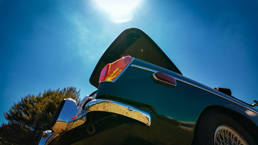 Sleek vintage Jaguar hood and chrome details captured in dramatic low angle shots.