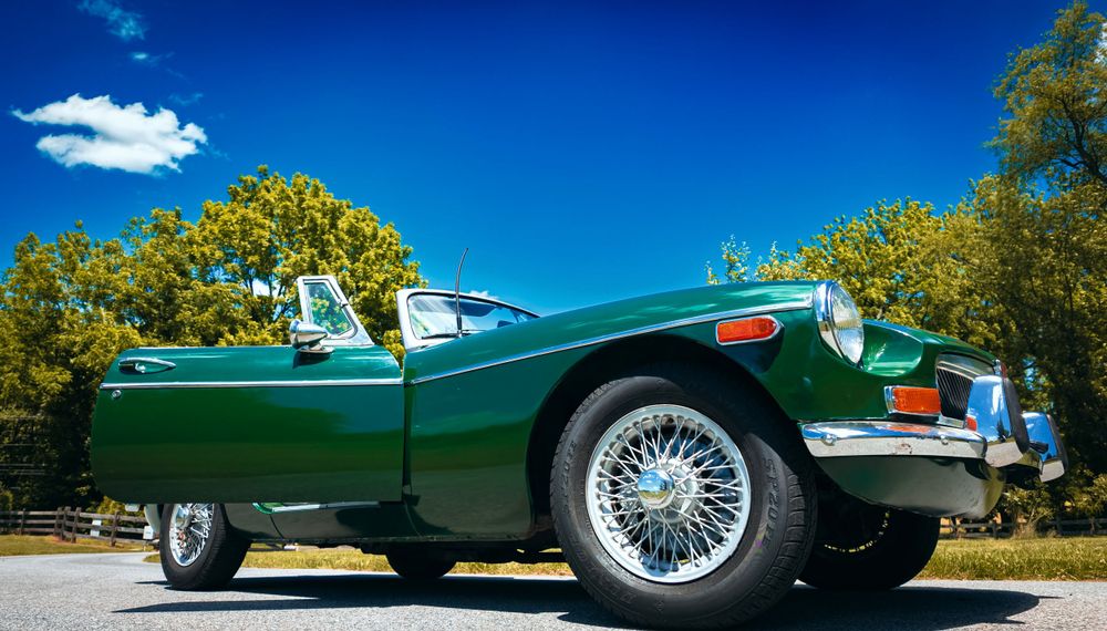 Wide angle landscape shots of a vintage Jaguar E-Type in pristine condition.