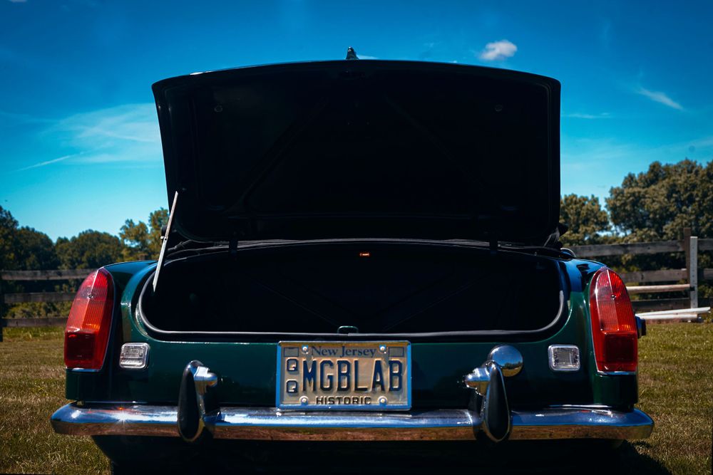 Series of rear view shots of a vintage Jaguar against bright blue sky.