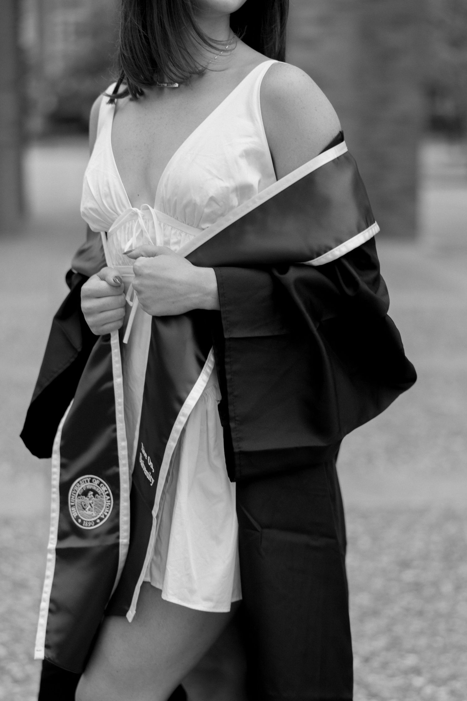 Black and white maternity portrait showing pregnant belly in white blouse and fitted skirt.