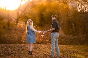 Couple enjoying a romantic moment in a field during golden hour with beautiful backlighting.