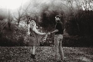 Black and white portrait of a couple standing together in a misty outdoor setting.