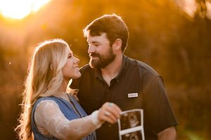 Sweet moment between couple during sunset with golden backlight creating a romantic atmosphere.
