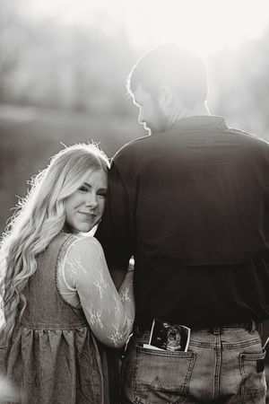 Artistic black and white silhouette of a couple sharing an intimate moment outdoors.