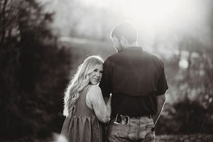 Black and white portrait capturing an intimate moment between a couple in nature.