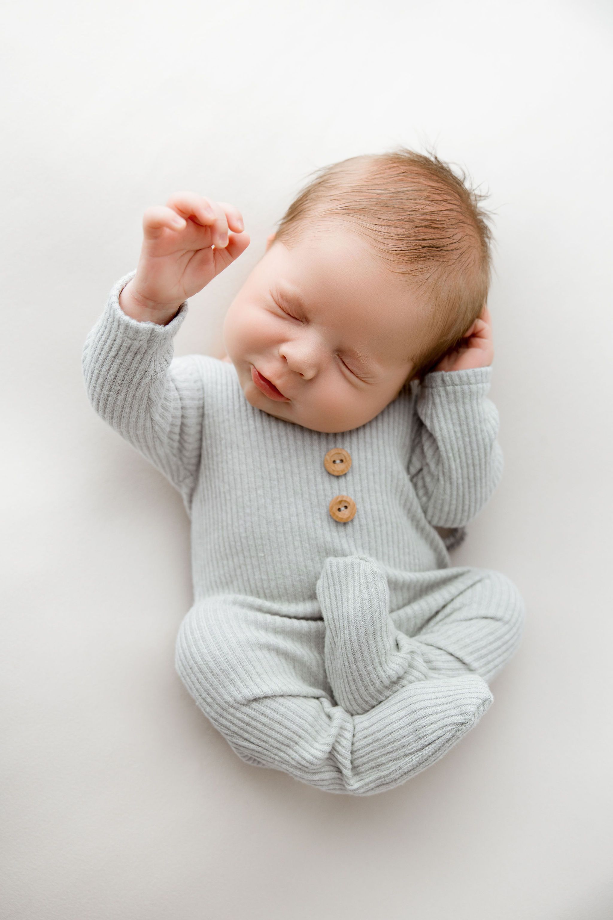 Newborn baby boy moving during a pose in the cutest way. Chicago newborn photography, studio located in Algonquin IL