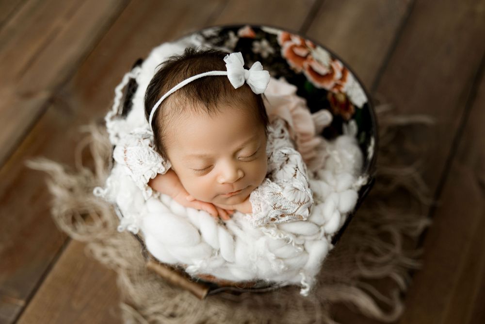 Newborn baby girl in a flowery bucket