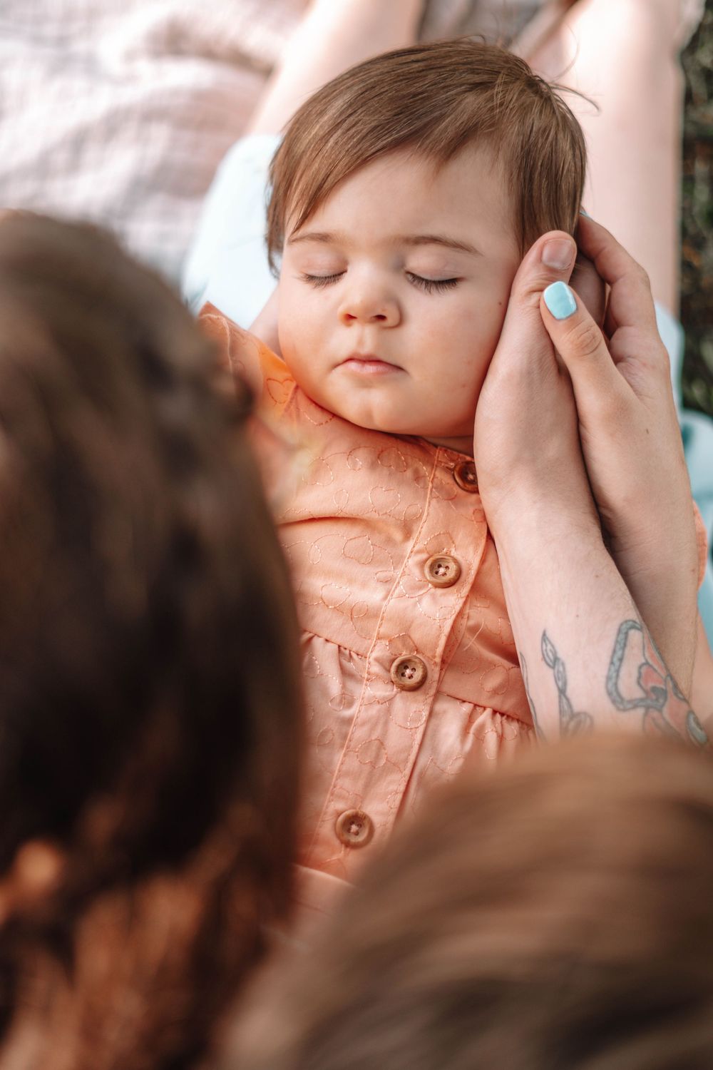 Close-up series showing tender moments between parent and child wearing peach colored clothing.
