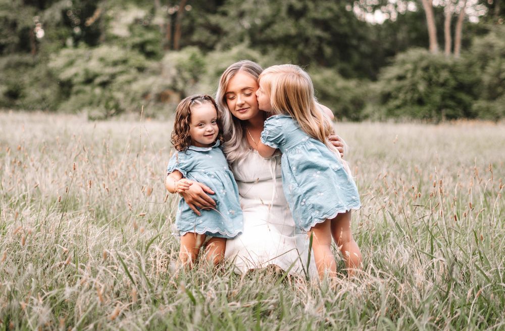 A playful moment captured in a sunny meadow with light and airy tones.
