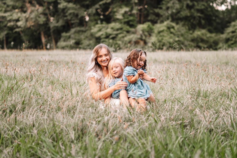 Joyful outdoor photography session in a natural grass field setting.