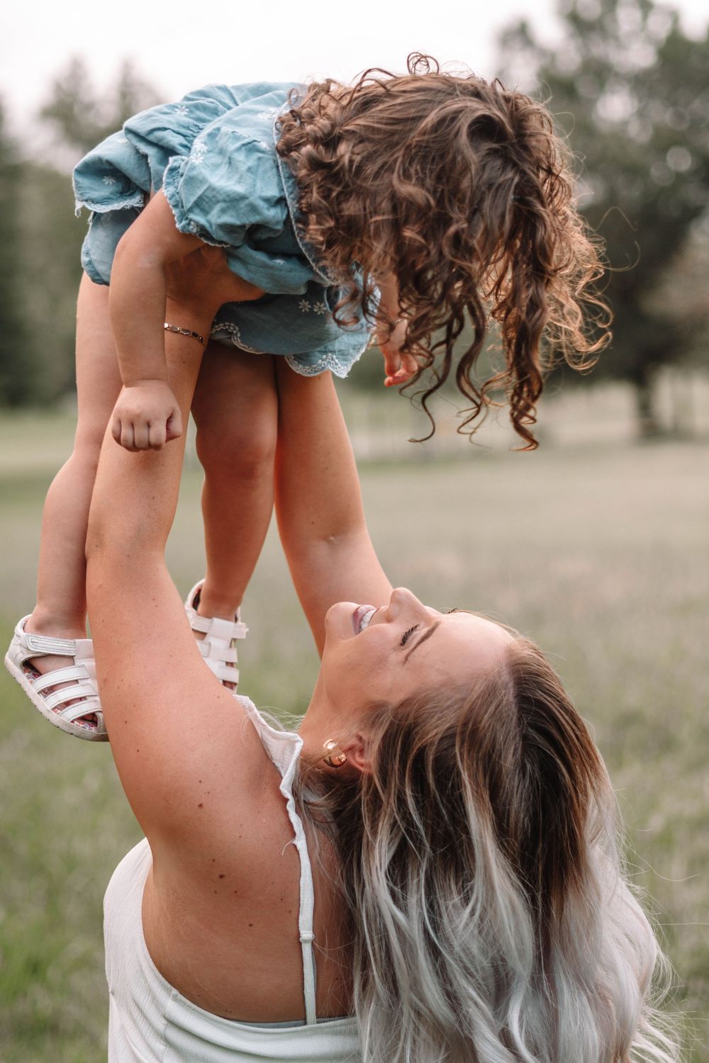 Candid outdoor portrait session showing playful interaction in a meadow.