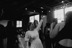 A joyful celebration moment captured in black and white during a wedding reception.
