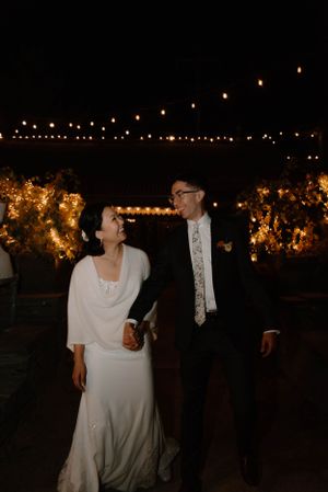 A wedding celebration at night with string lights creating a magical outdoor atmosphere.