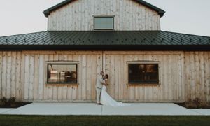 Rustic barn wedding venue with weathered wood siding and modern architectural details.