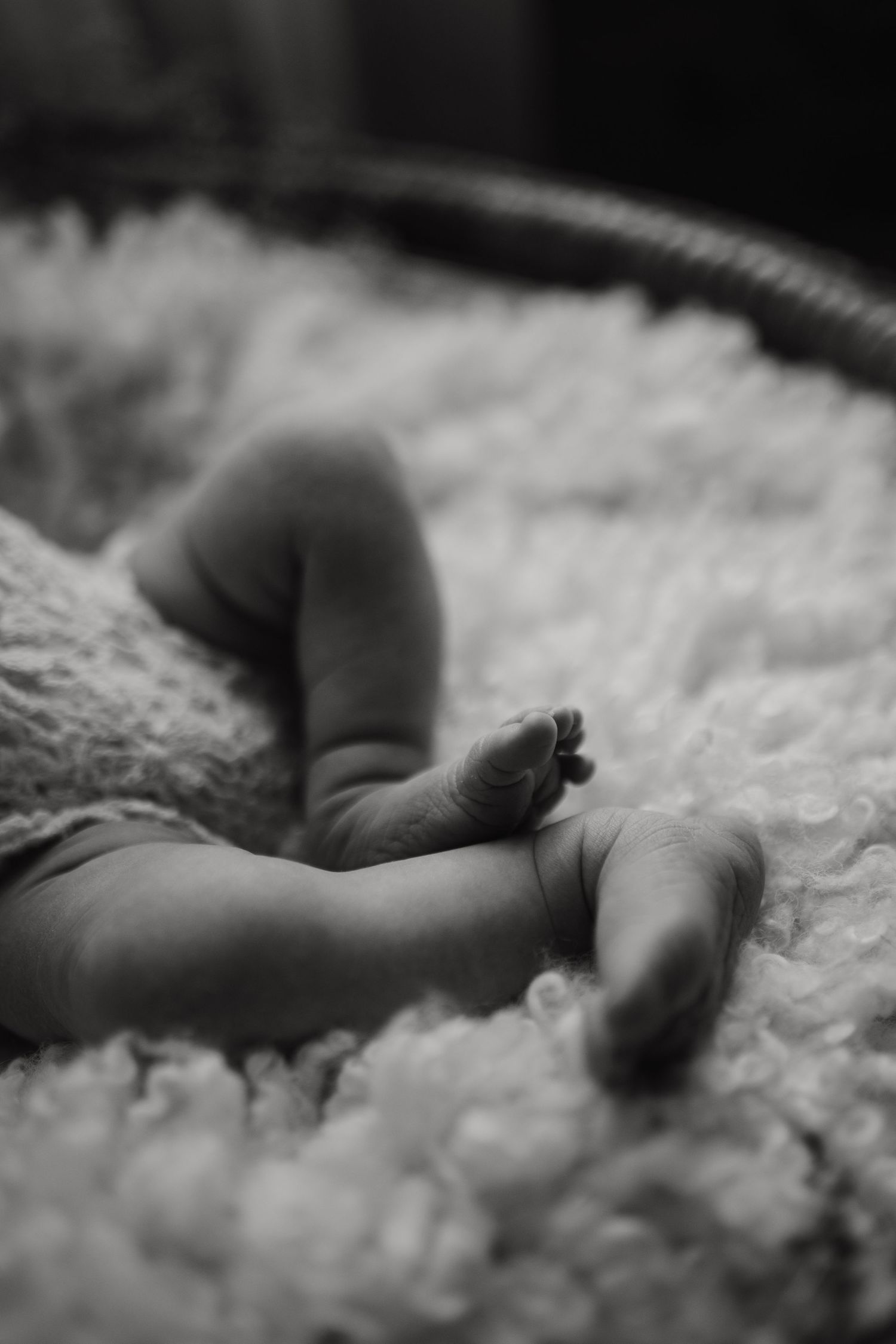 Tender moment with baby being held against dark clothing.