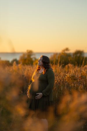 A couple embraces in a golden field at sunset creating a romantic silhouette against the warm evening light.