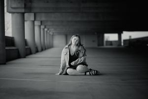 Artistic black and white portrait in urban concrete corridor.