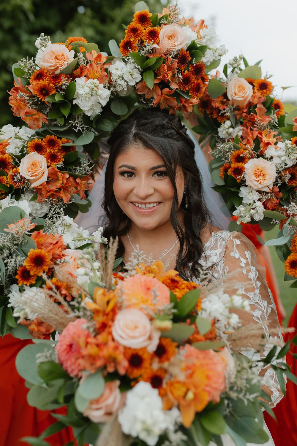 Beautiful autumn wedding floral arch with orange and peach roses framing the special moment.