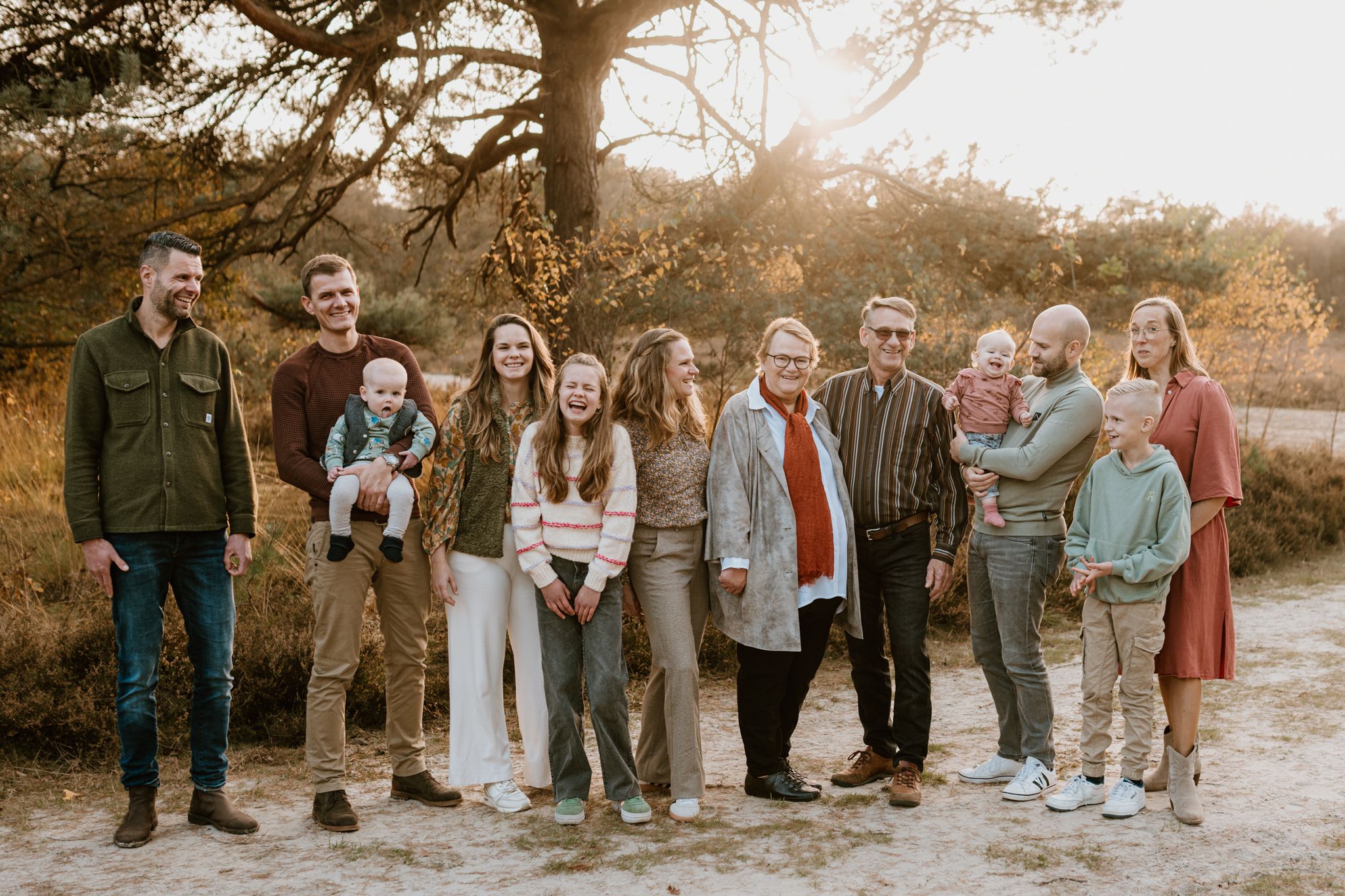 Grote familie tijdens zonsondergang in Drenthe. Familiefotoshoot spontaan en niet geposeerd.