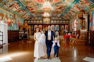 Ornate ballroom with painted ceiling murals, chandeliers, and gilded details showcases elegant Russian palace architecture.