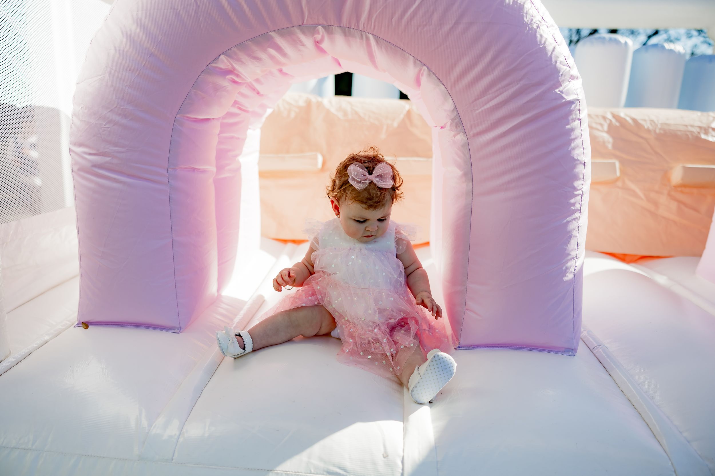 Pink inflatable bounce house or play structure set up for a party or event.