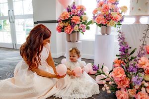 A wedding photoshoot montage featuring white dresses, floral arrangements in coral and purple, and elegant decor details.