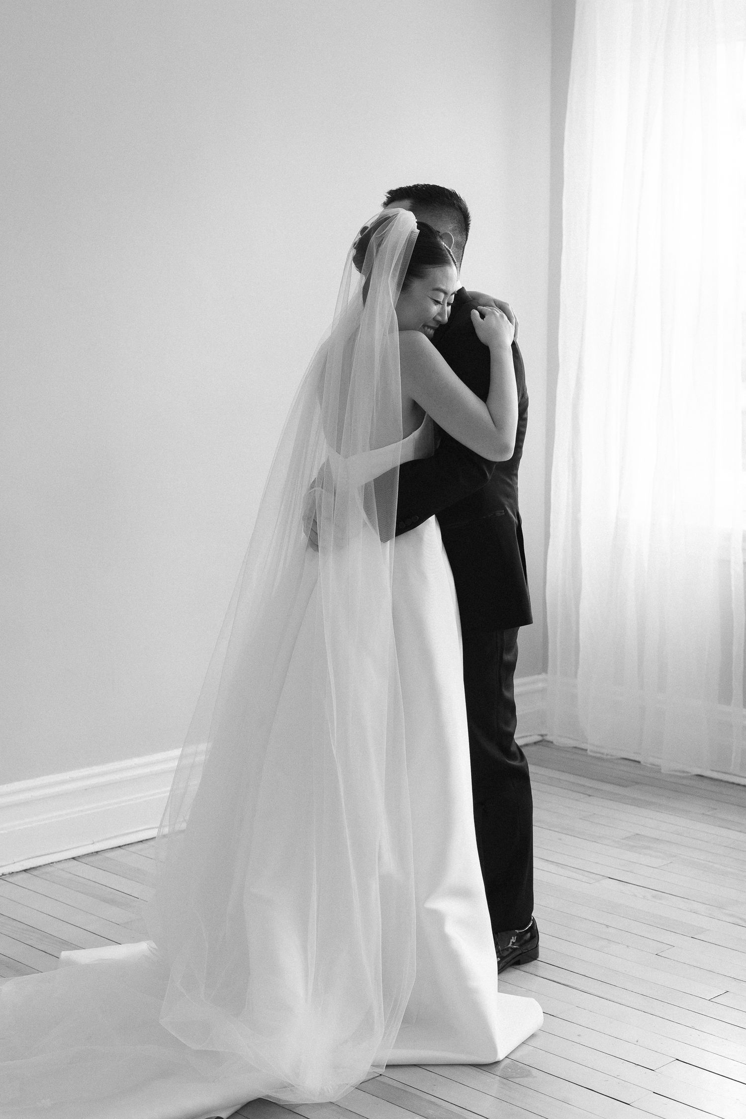 Bride in lace top and white pants holds groom's hand walking down urban outdoor steps.