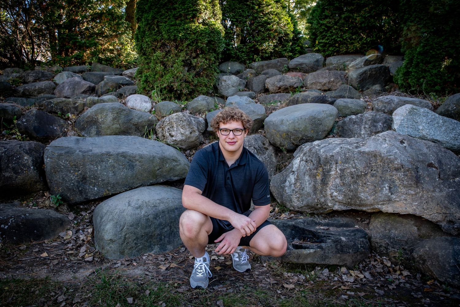 Outdoor portrait on rocky terrain surrounded by natural landscaping.