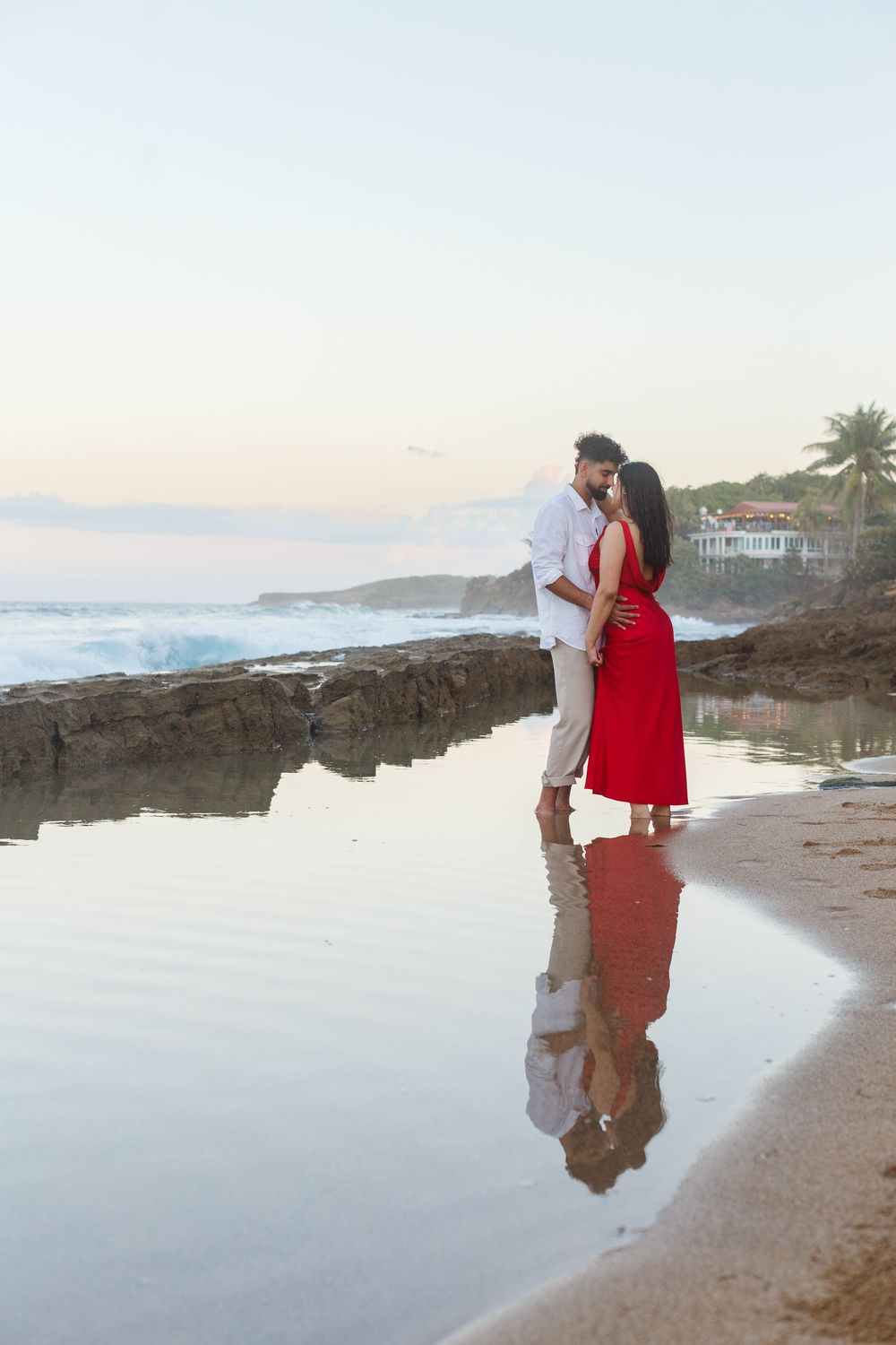 Couples portrait with their reflection in the water. On the beach at Kikita Beach in Dorado, Puerto Rico.