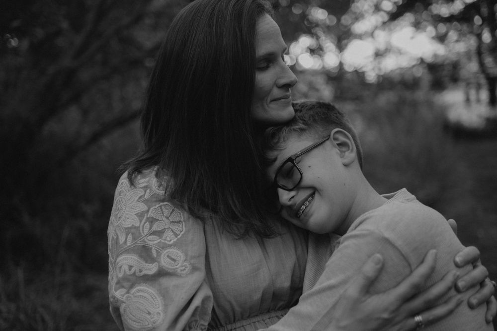 Warm, candid photograph of a mother and her young son embracing