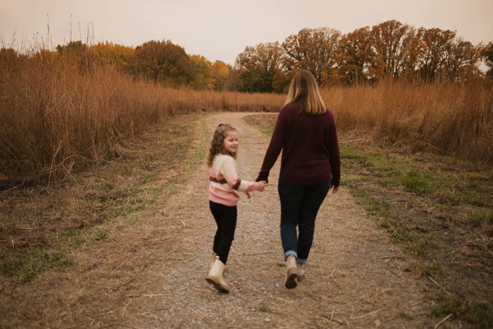mother and daughter walking in a path with one another
