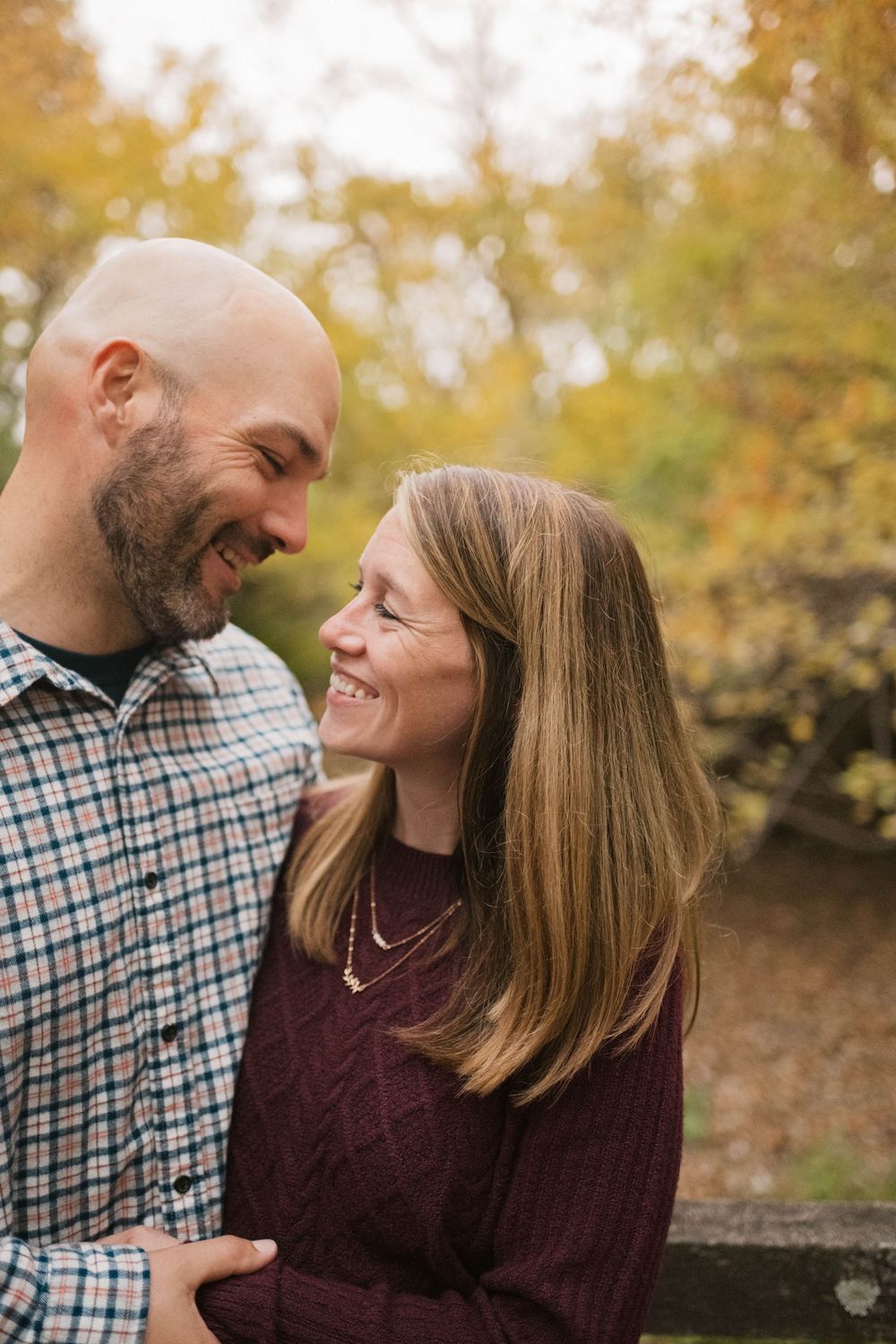 Candid photograph of a husband and wife laughing together during an outdoor lifestyle photography session in Illinois.