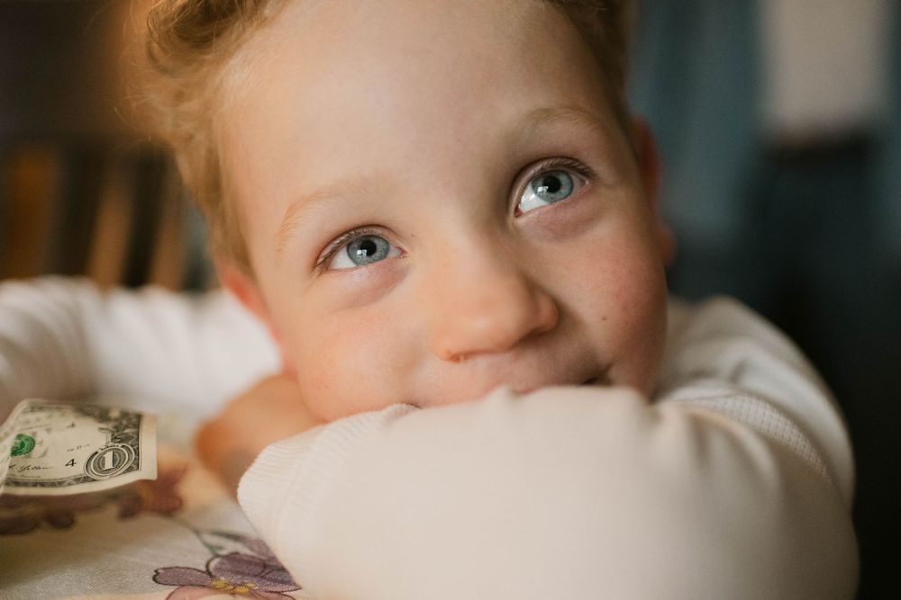 Authentic lifestyle photography of a toddler boy looking directly into the camera, capturing a candid and joyful express