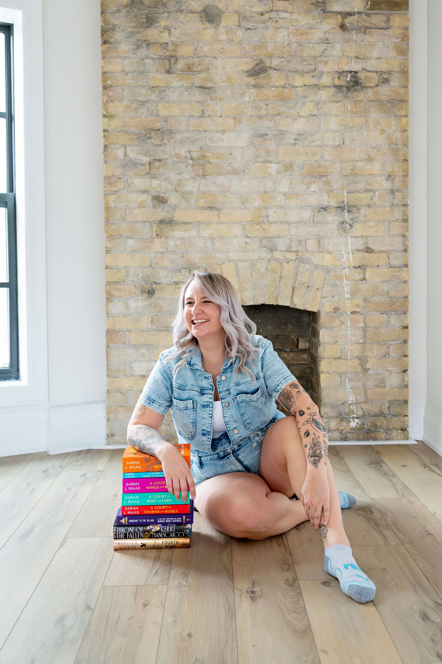 Person in mint sweater lounging on white couch with Onyx Studios book.