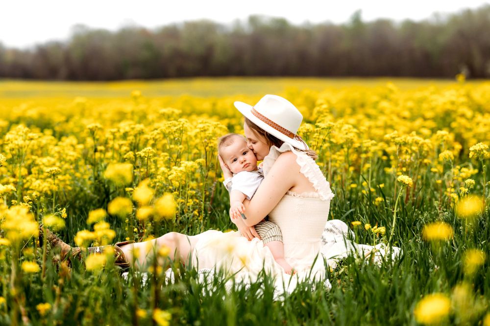Mother and baby sharing tender moment in field of yellow wildflowers Waterbury, CT.