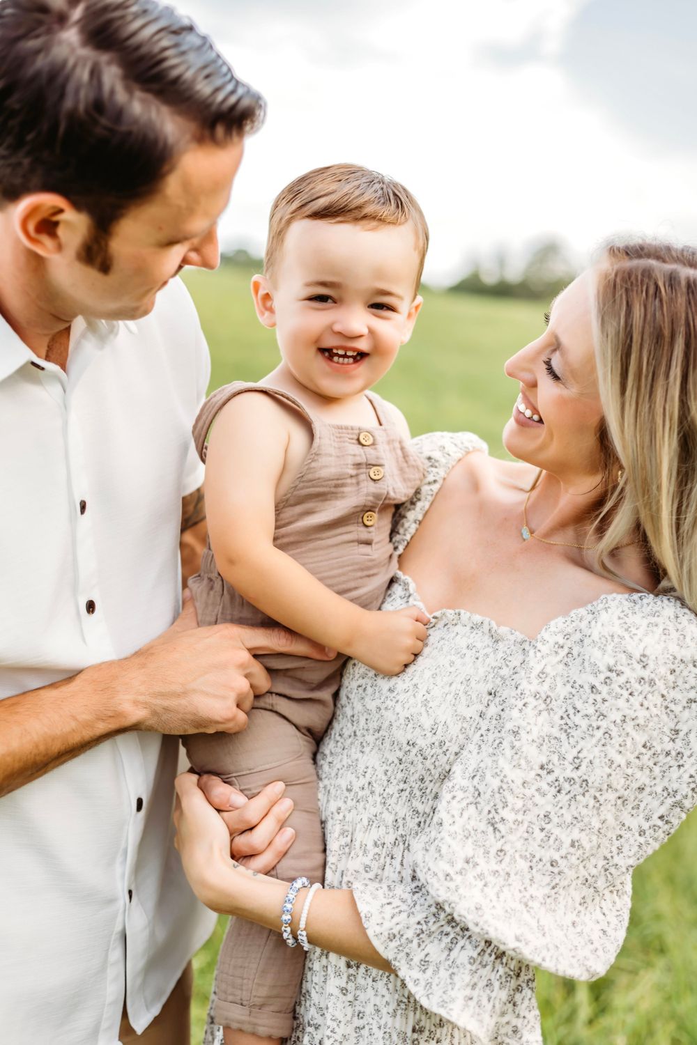 Candid family moments captured in outdoor field setting with natural lighting in Branford, CT.