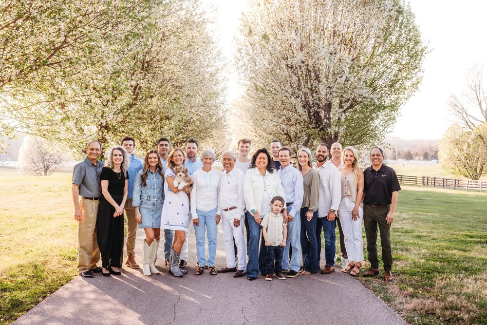 Large family group poses together outdoors in coordinated neutral outfits during golden hour photo session in Hamden, CT.