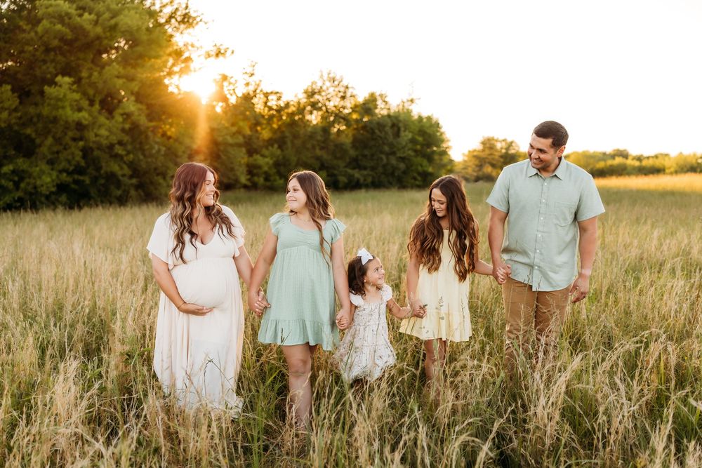 Family walks in a field in Meriden, CT celebrating maternity photo shoot