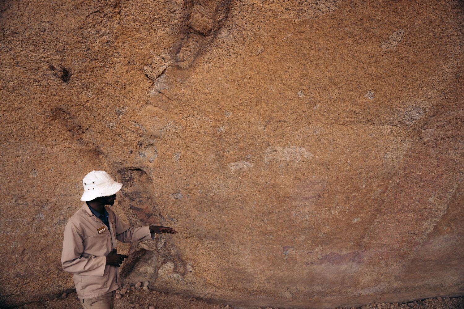 guide qui donne des explications sur des peintures rupestres à spitzkoppe