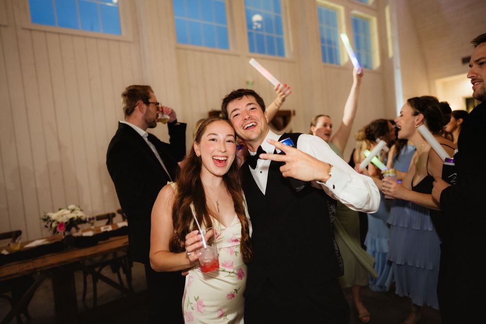 Bride and groom smiling and taking a selfie at their wedding reception party.